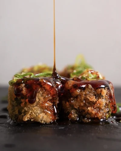 Close-up de sushi, com molho sendo derramado por cima